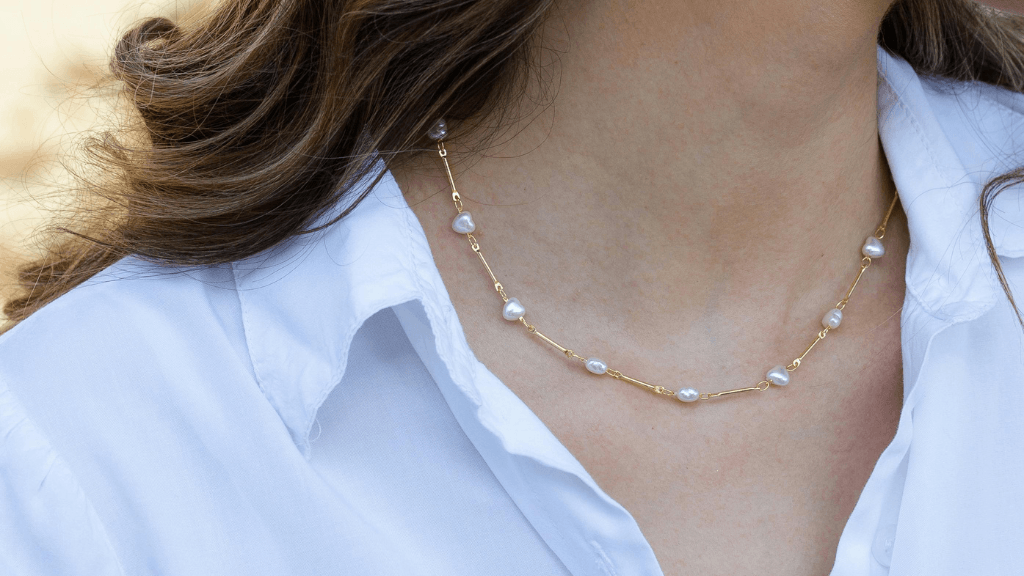 woman wearing heart pearl necklace