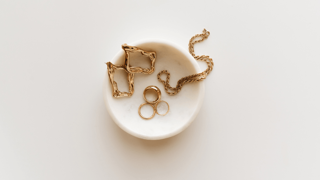 gold jewelry sitting in a white dish