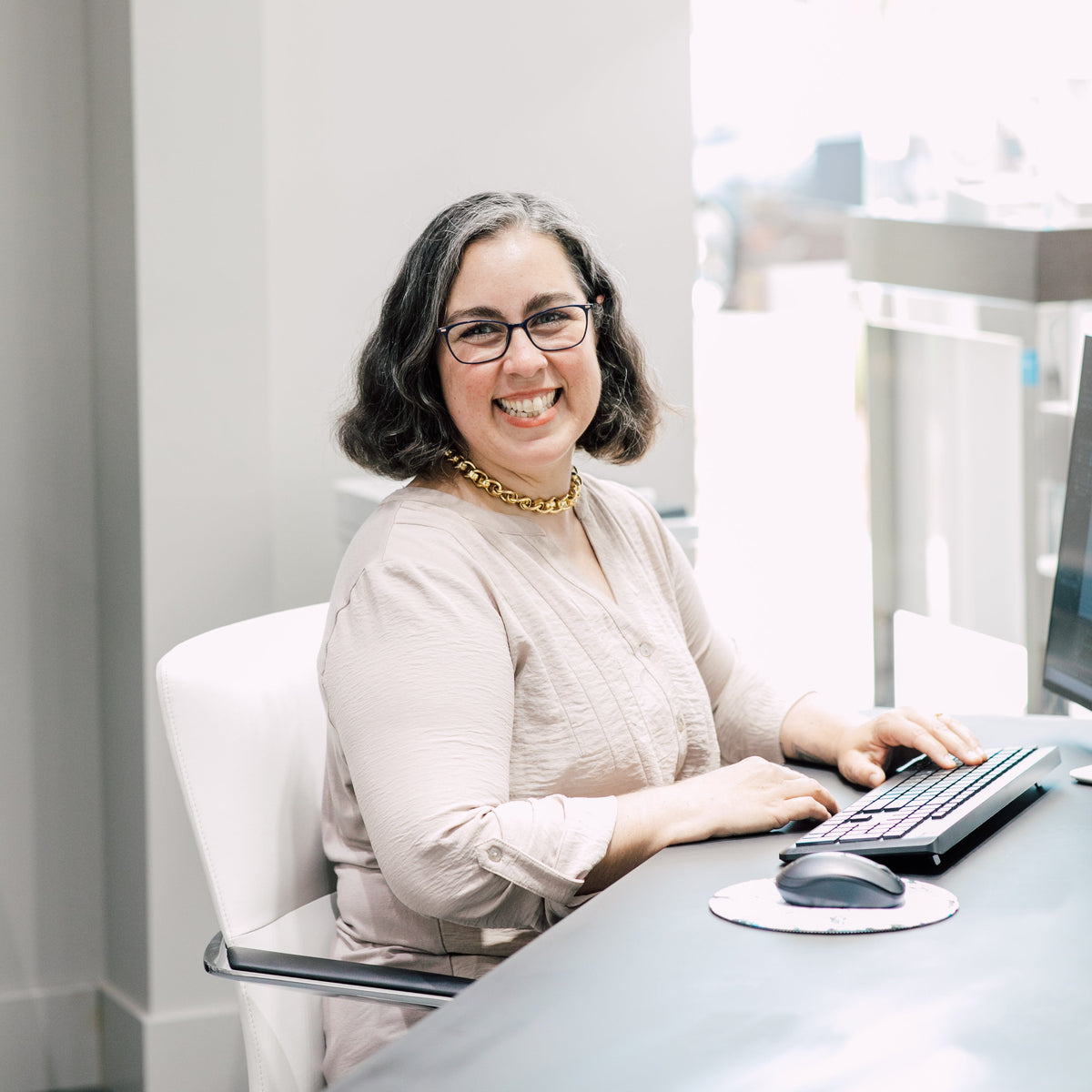 A smiling woman sits behind a desk in a jewelry store in Bellingham, WA